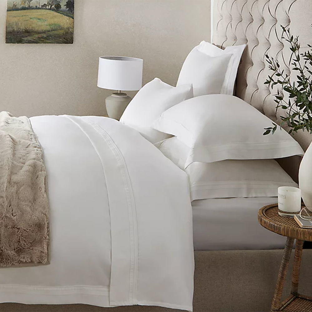 Neutral bedroom with white cotton sheets on the bed