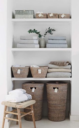 Simple but clever storage solutions. Blankets, towels and baskets in bedroom alcove store.