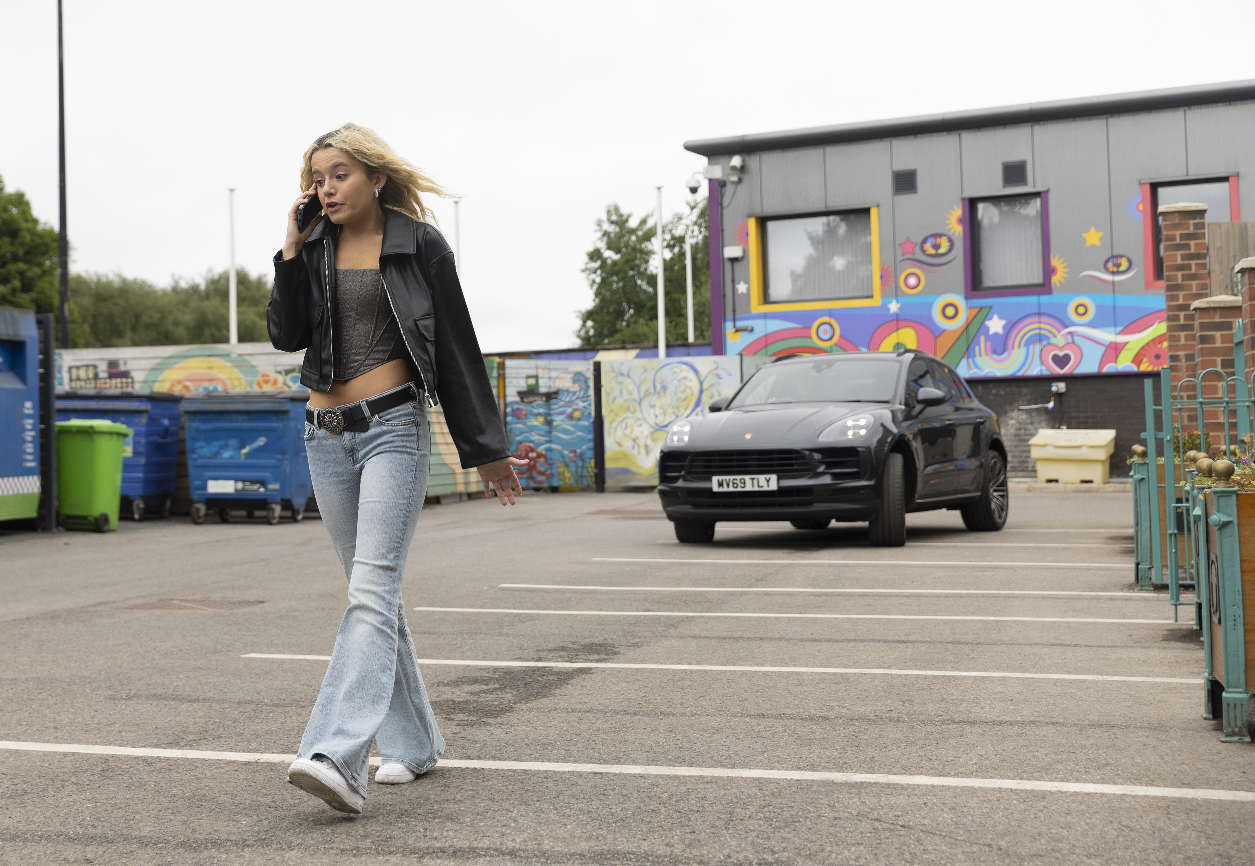 A car speeds up behind Betsy while she&#039;s on the phone