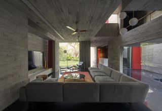 concrete interior living space at Trees Sliced Through by Matharoo Associates