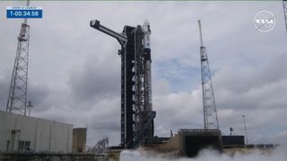 A SpaceX black and white rocket with its Crew Access Arm retracted for launch.