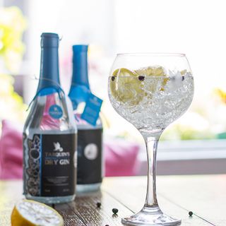 gin bottles wine glass and lemon on table