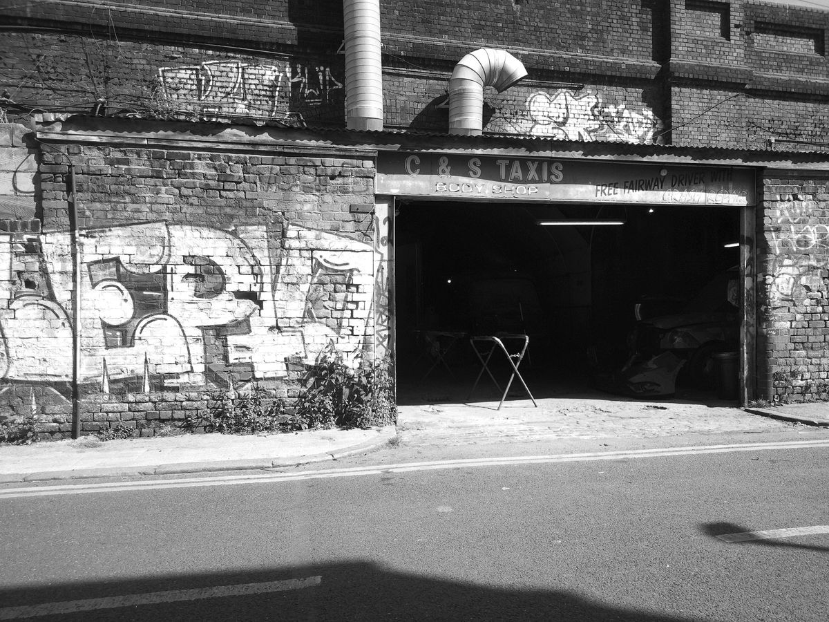 Camp Snap CS-Pro sample image showing garage next to graffiti-covered wall, image is monochrome