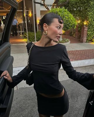 Woman wearing black miniskirt and long-sleeve top.