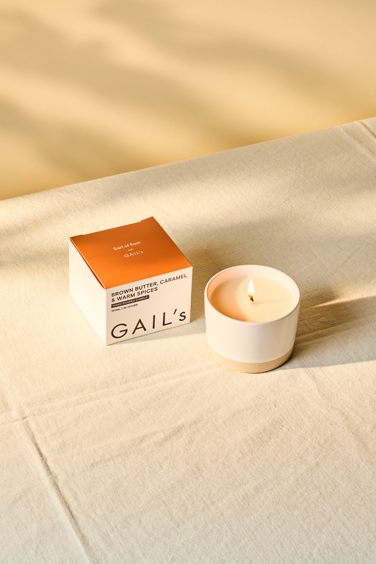 A white ceramic candle on a linen tablecloth