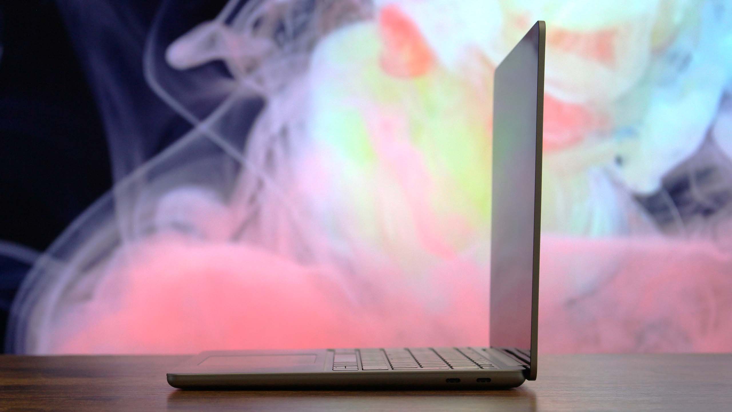 Surface Laptop 13-inch right side profile in an open position in front of an abstract background.