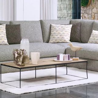 grey coloured sofa with cushion floor rug and coffee table