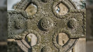 Close up of a ancient Celtic cross made out of stone.