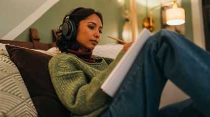 Audio-Technica ATH-M20xBT review: woman writing on a notepd with headphones on
