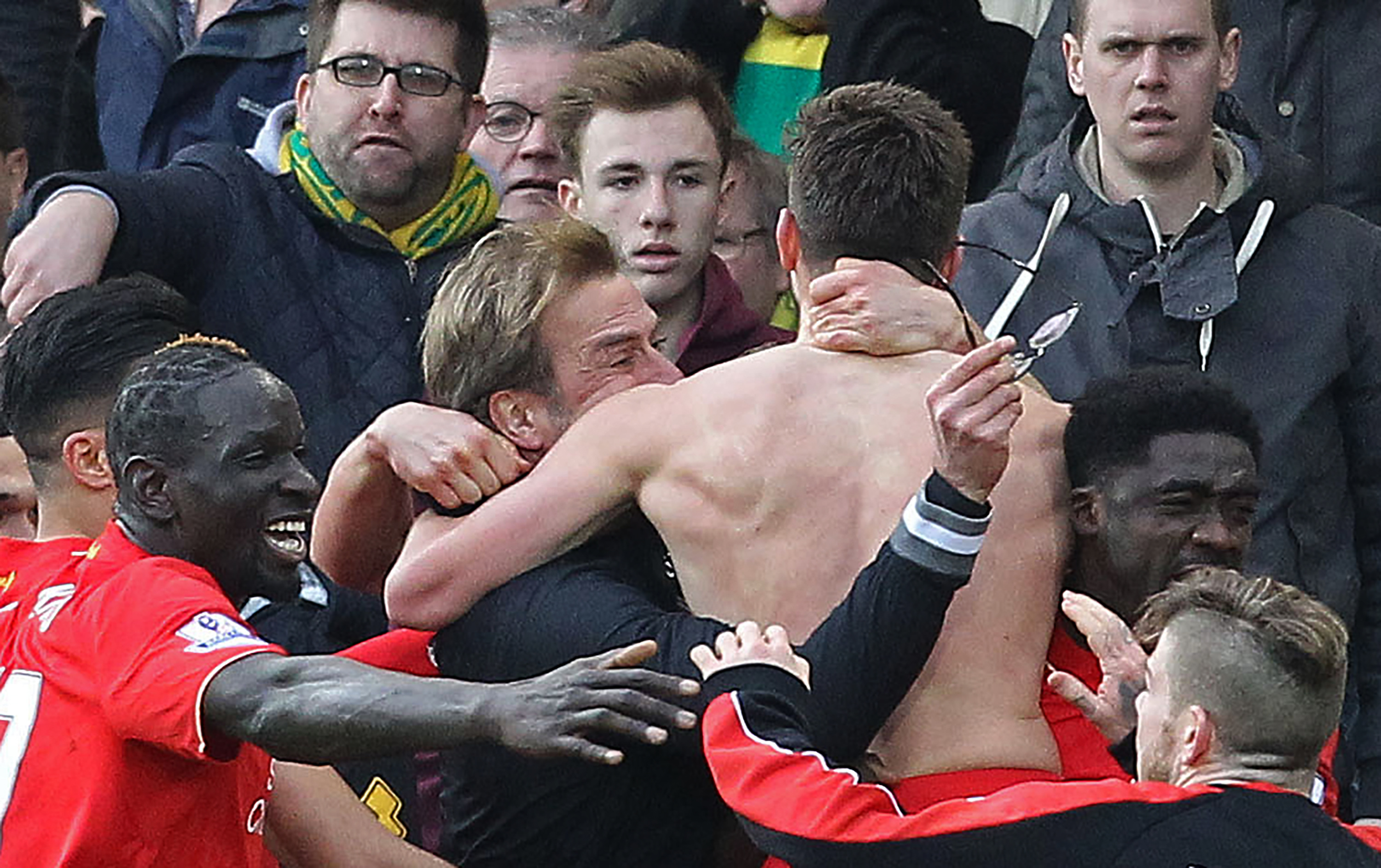 Jurgen Klopp holds his glasses as Liverpool players and staff celebrate Adam Lallana's winner in a 5-4 victory at Norwich in January 2016.