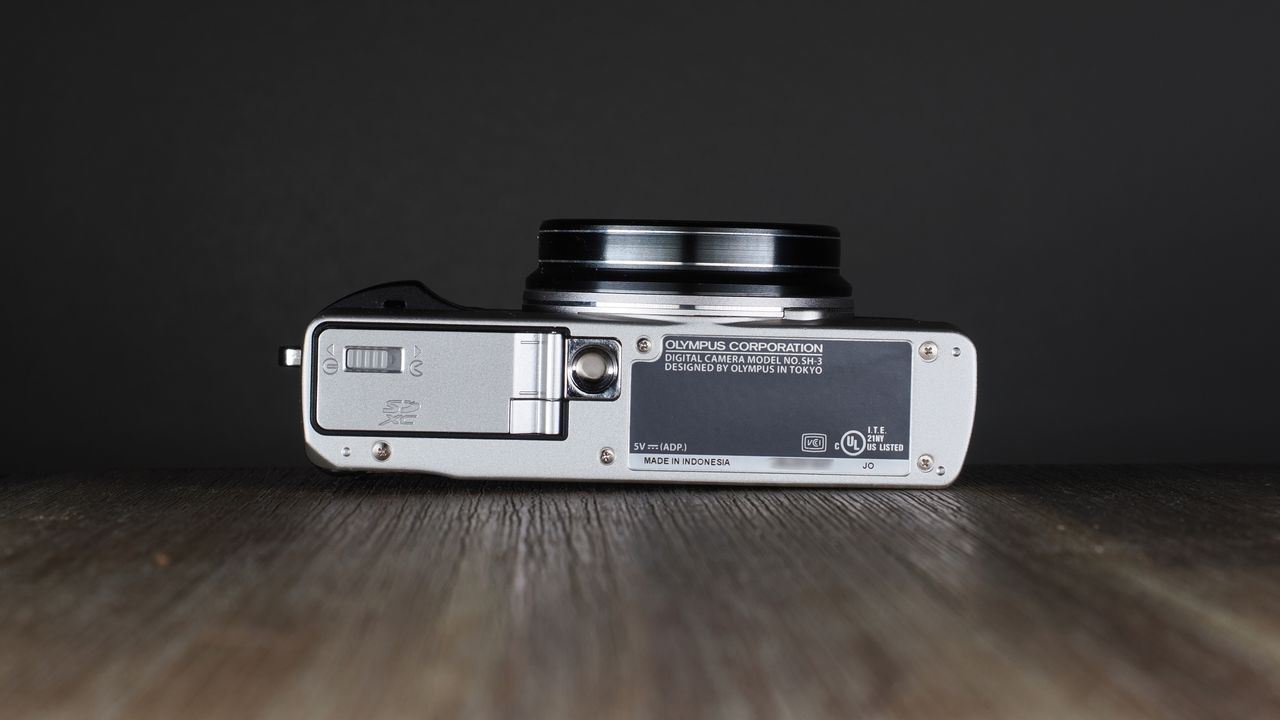 Olympus Stylus SH-3 on a wooden surface