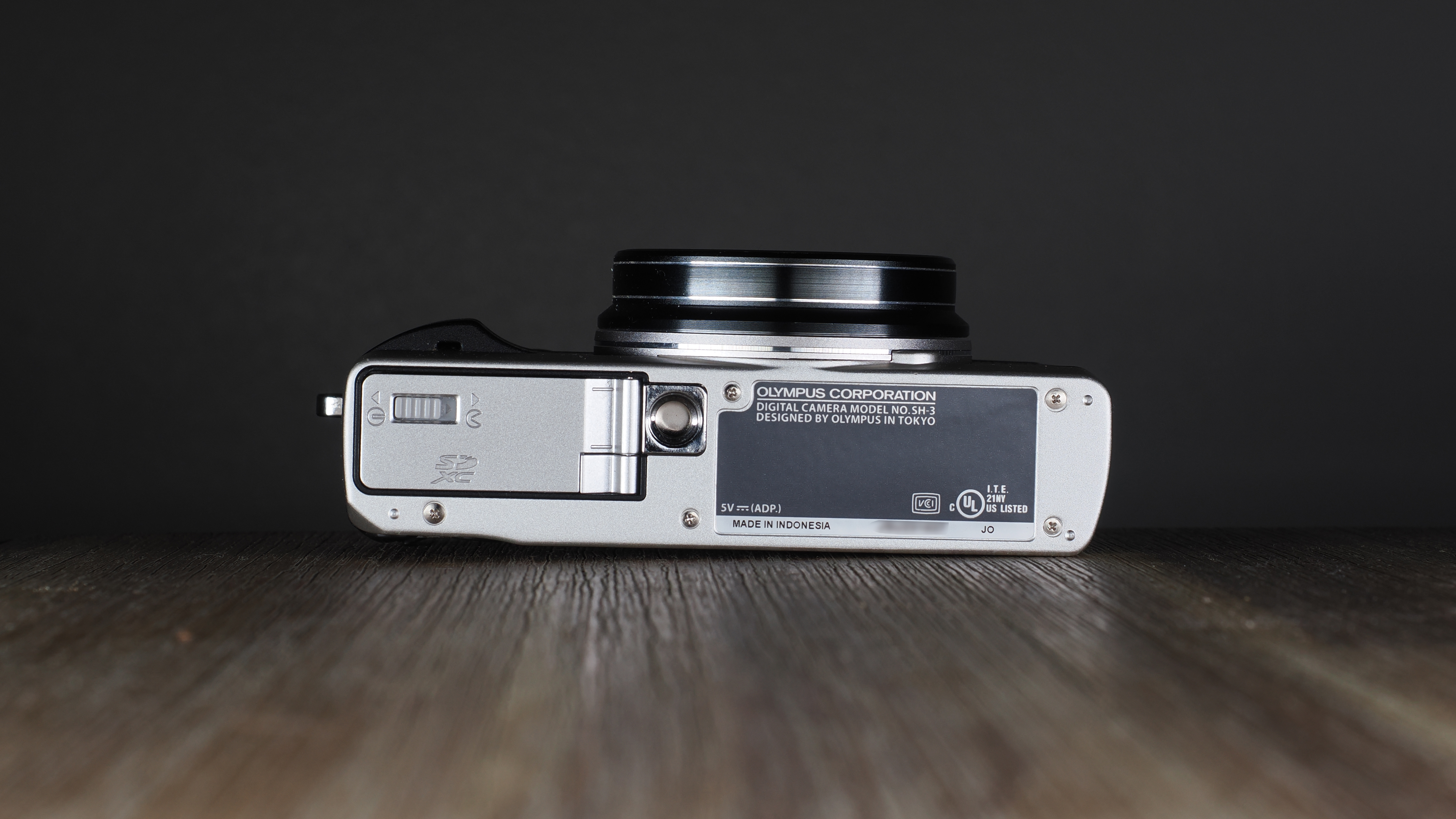 Olympus Stylus SH-3 on a wooden surface