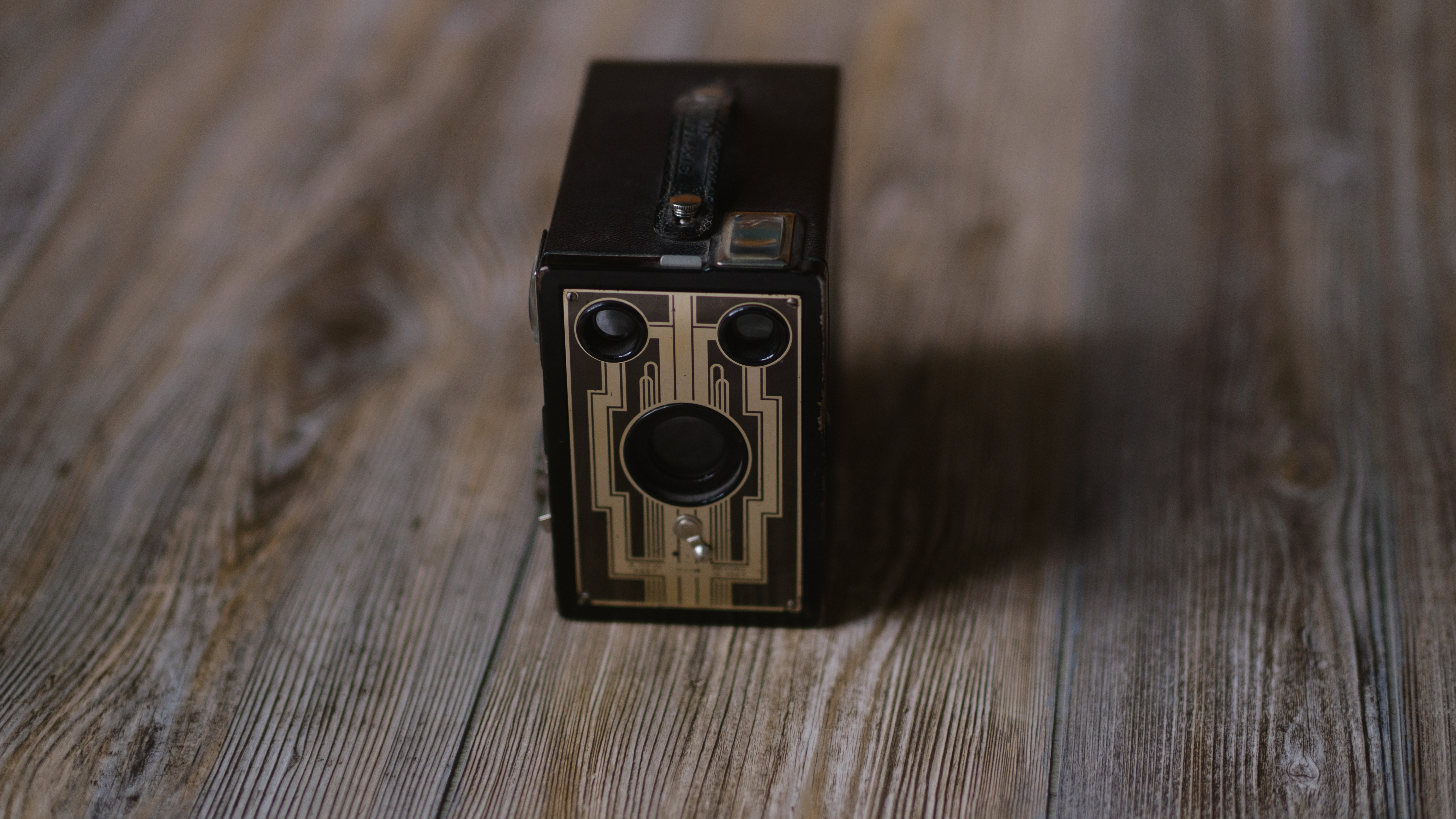 A photo of a vintage box camera taken under different lighting conditions