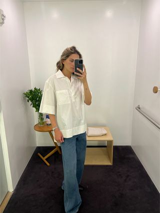 Eliza Huber wears a short-sleeved white poplin shirt and jeans at the COS store.