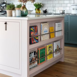 pale pink kitchen island with book storage at the end