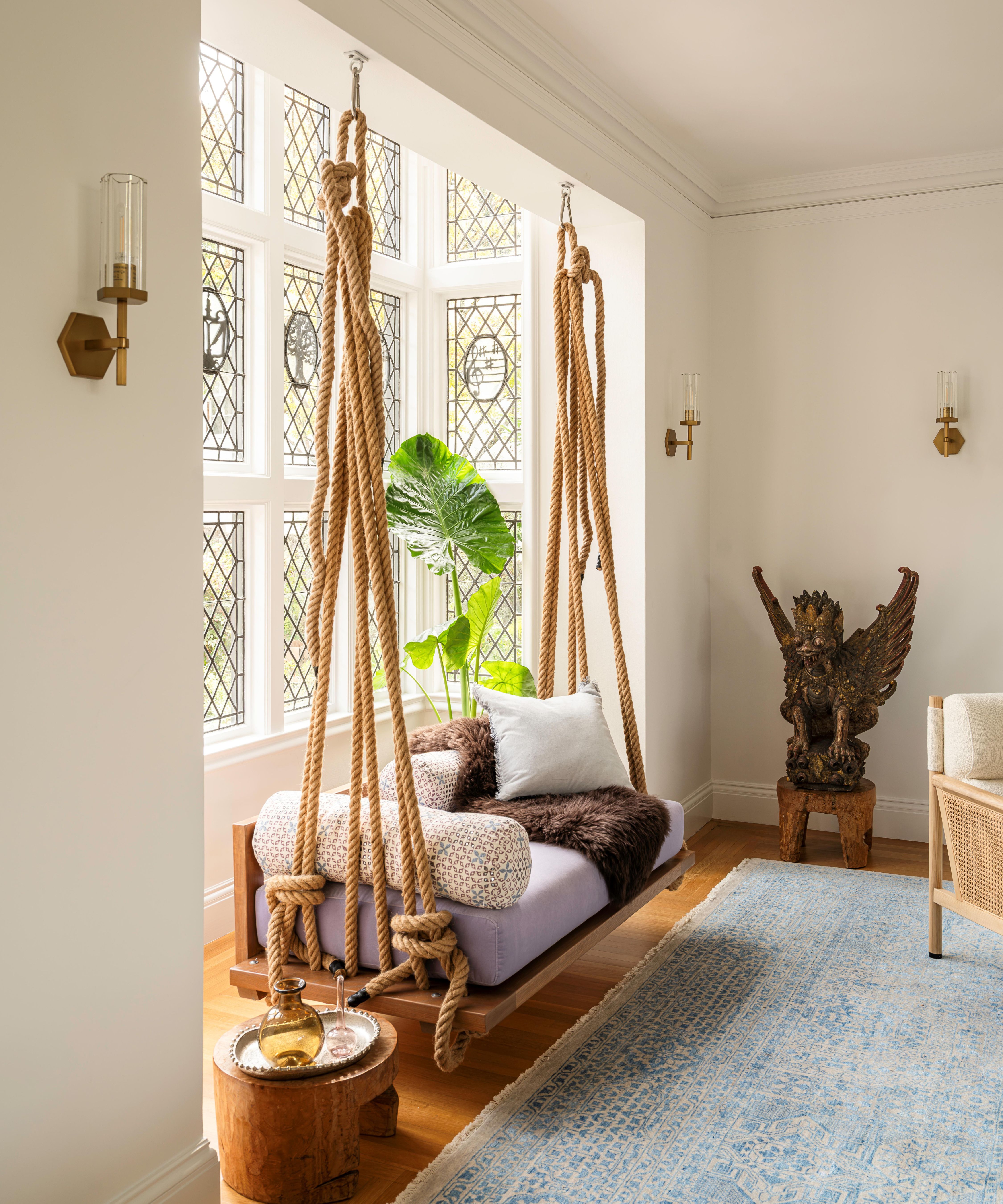 a tudor living room bay window with original leaded windows with an indian rope swing suspended from the ceiling