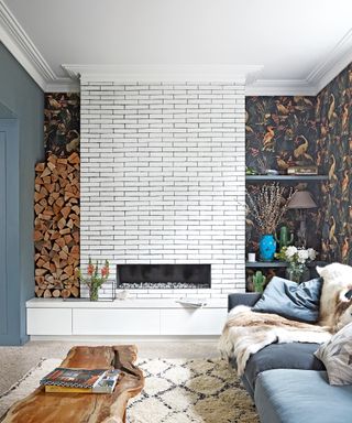 A white brick fireplace, feature wallpaper and blue sofa illustrated bohemian living room ideas.