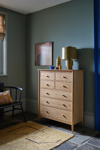 slim wooden chest of drawers in blue room