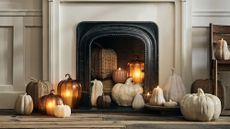 Crate & Barrel fall 2025 pumpkin decorations in wicker, ceramic, and papier mache inside of a cream and black fireplace.