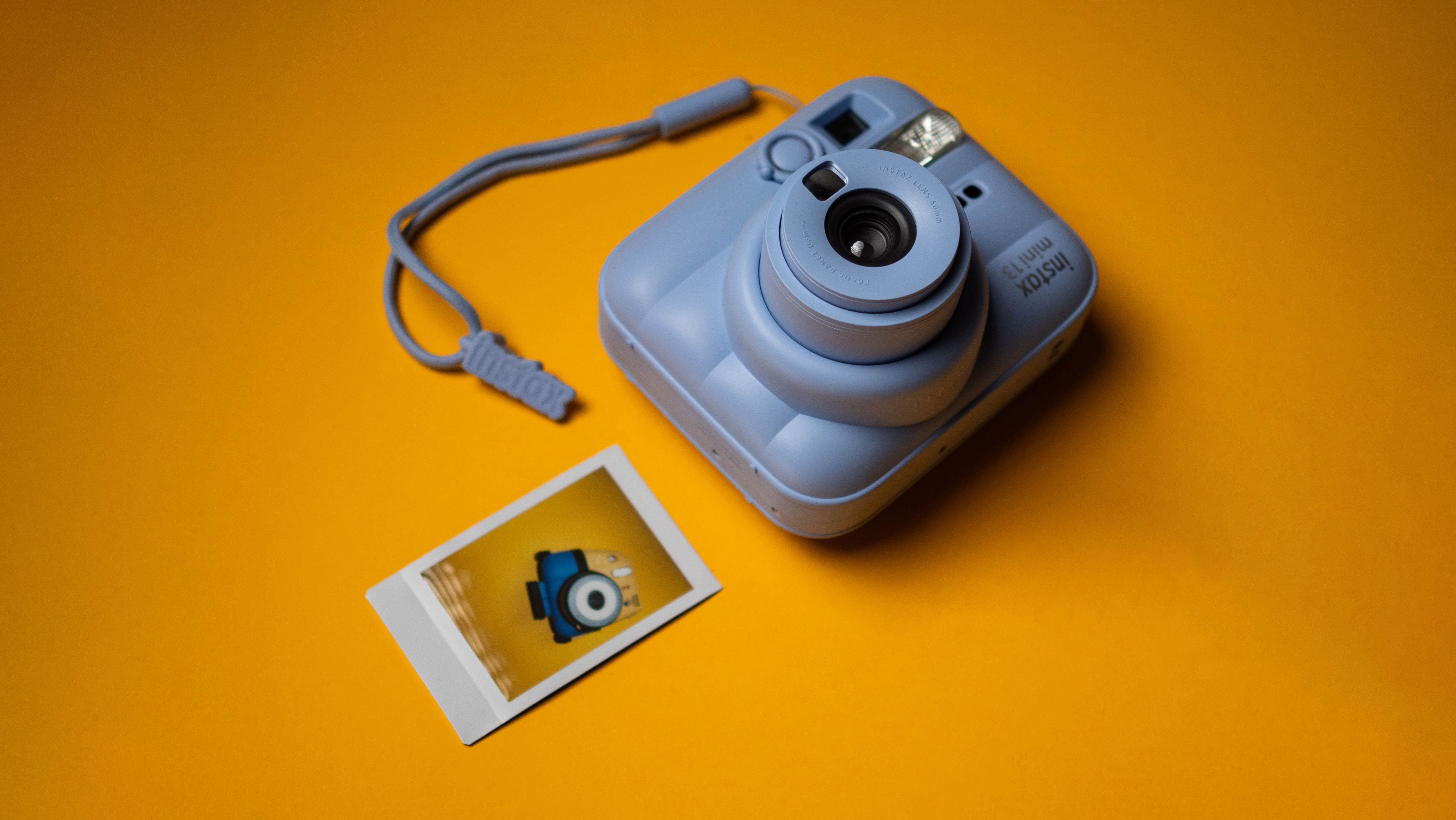 Fujifilm Instax Mini 13 instant camera against a yellow colored sheet