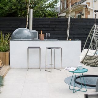 outdoor kitchen with white counter and swing chair