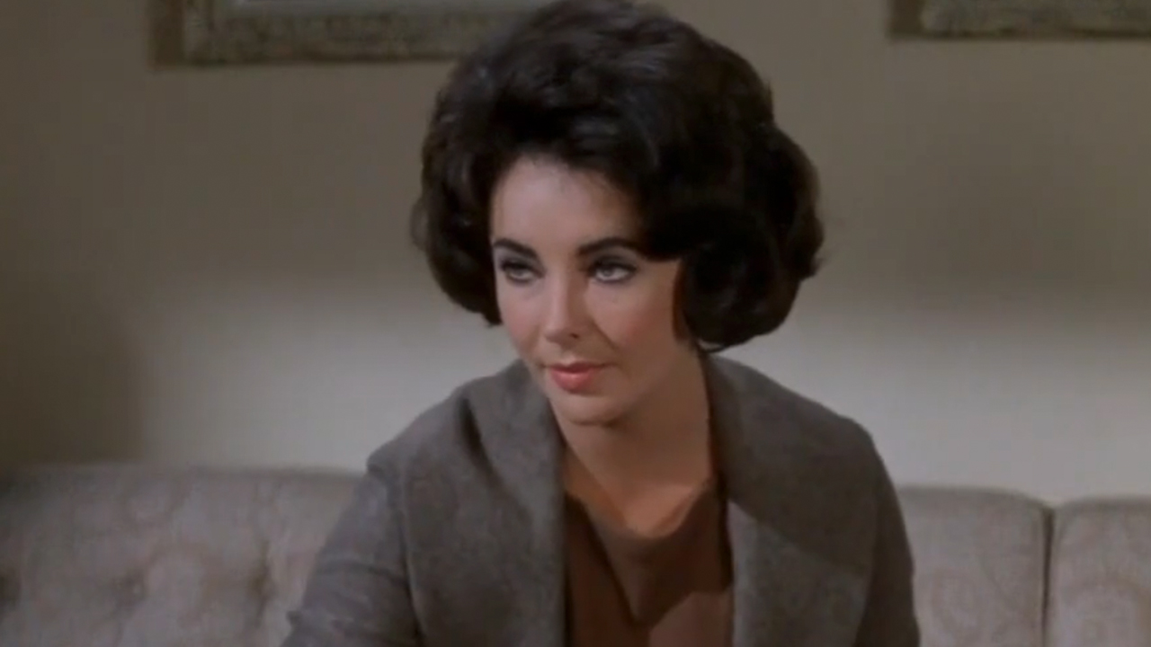 Elizabeth Taylor in a grey jacket looking suspicious in Butterfield 8
