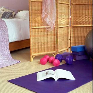 bedroom with pink and purple dumbbells and yoga mat