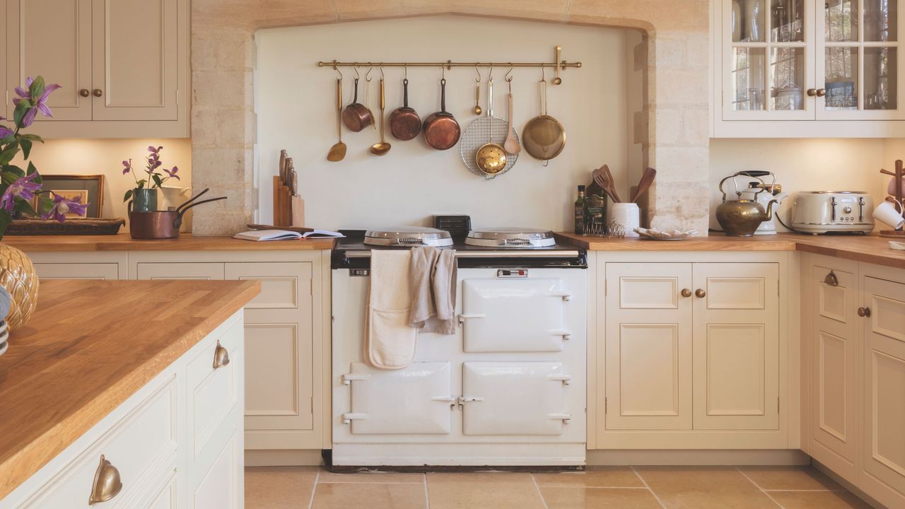 country kitchen with cream cabinetry and walls with white aga