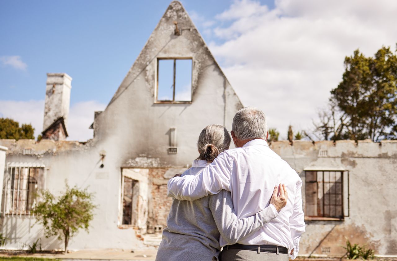 Couple looking at home after fire 