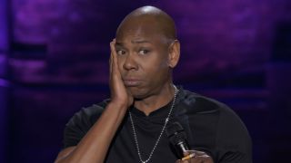 Dave Chappelle with hand on cheek in The Dream stand-up special