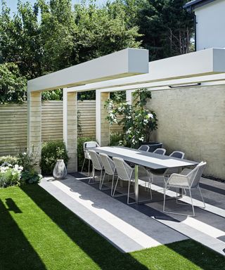 A modern example of patio cover ideas showing a contemporary structure with three concrete plinths
