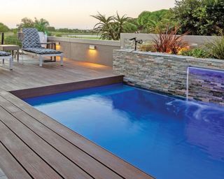Brazilian Teak dark brown composite apex deck board used in back garden with outdoor pool and deck chair decor