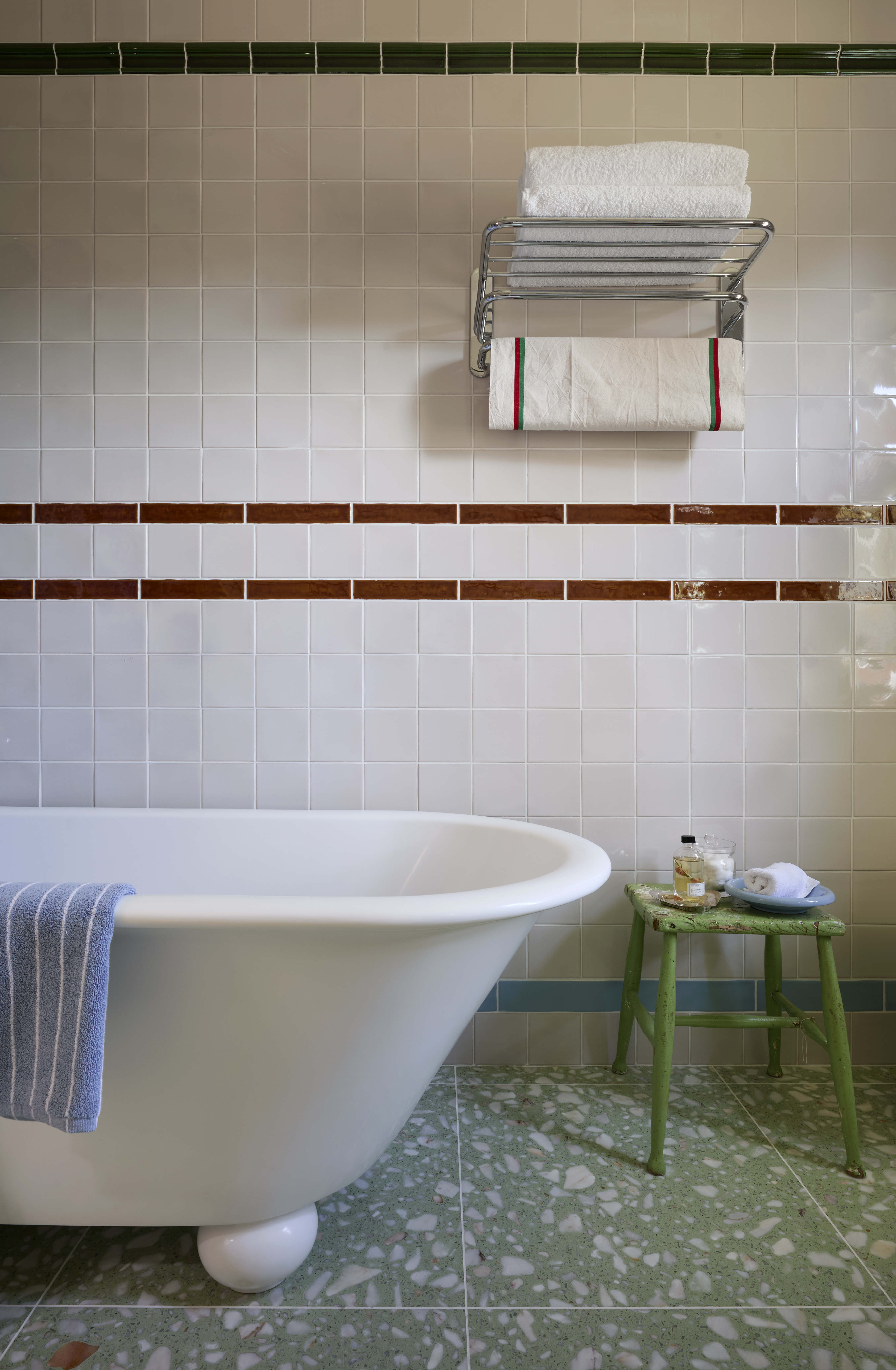retro tiled bathroom with terrazzo floors and a towel rack, shelf hybrid