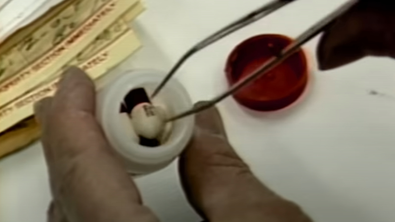 A hand examining a bottle of pills in Cold Case: The Tylenol Murders