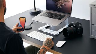 Man at desk with range of Griffin accessories and other devices