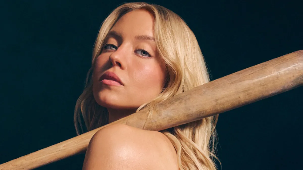 Cropped shot of Sydney Sweeney's head and bare shoulder as she looks into the camera holding a baseball bat