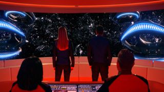 A still from "The Orville" showing the crew of the Orville staring out from the ship at a debris field in space.
