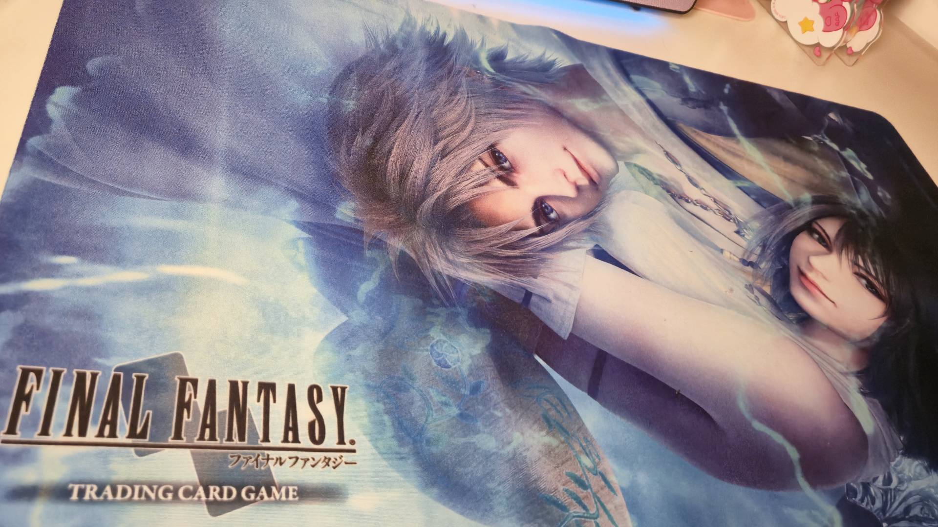 Photo of the Final Fantasy 10 playmat from the Final Fantasy TCG, sitting on a white desk.