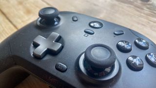 A black GameSir T4 Cyclone Pro controller sitting on a wooden desk