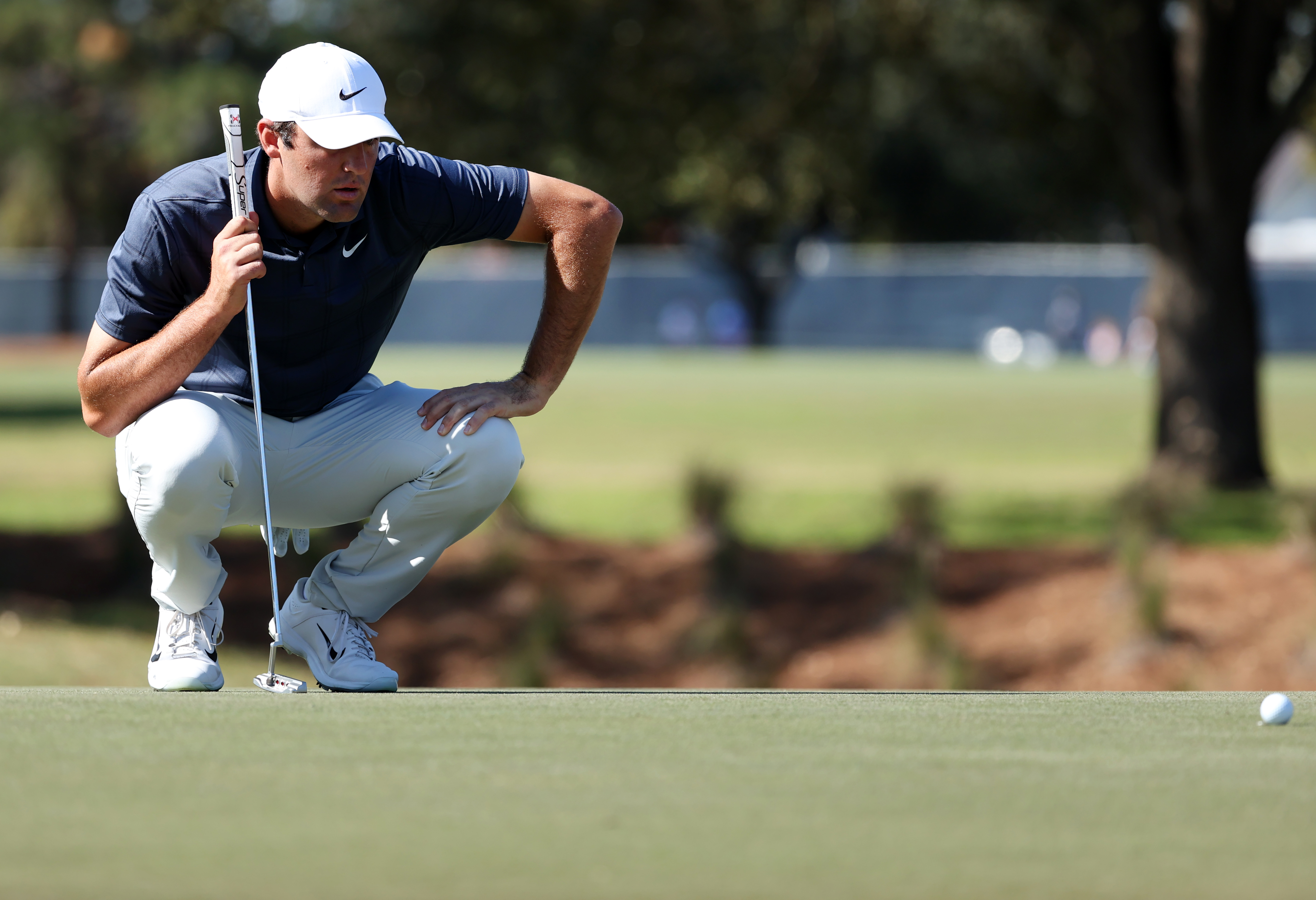 Scottie Scheffler lines up a putt