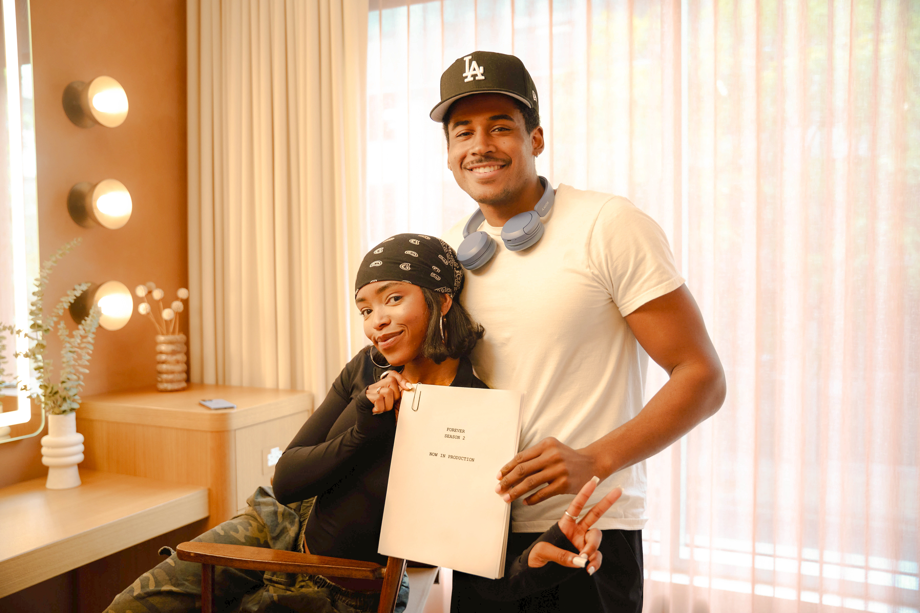 lovie Simone and Michael Cooper Jr. pose together smiling backstage while holding a script for forever season 2 as the show begins production