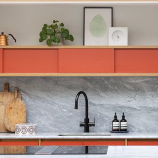 Kitchen with orange painted cabinetry