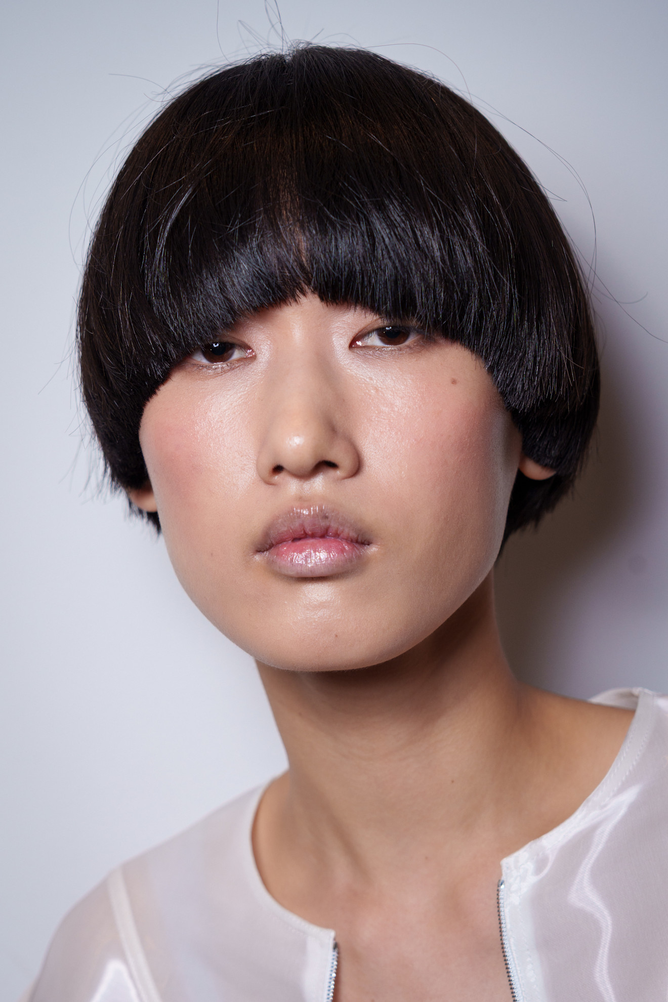 bowl cut bangs with a white chiffon top and frosted makeup
