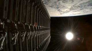 a stack of satellites are deployed into Earth orbit with the full sun visible