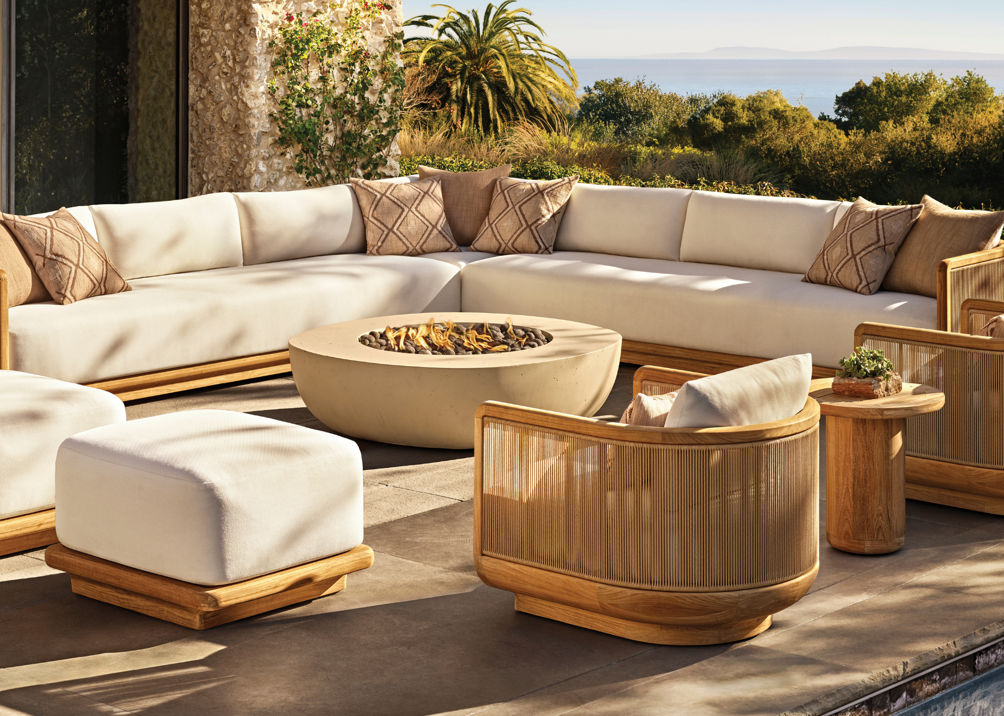 large outdoor living room with a fire pit and white outdoor sofa