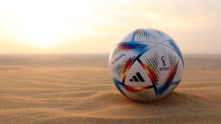A World Cup 2022 football lodged in the sand