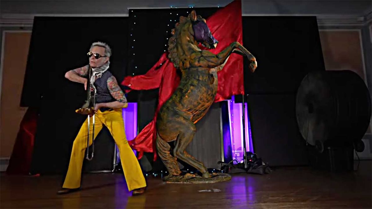 David Lee Roth dancing in front of a statue of a horse 