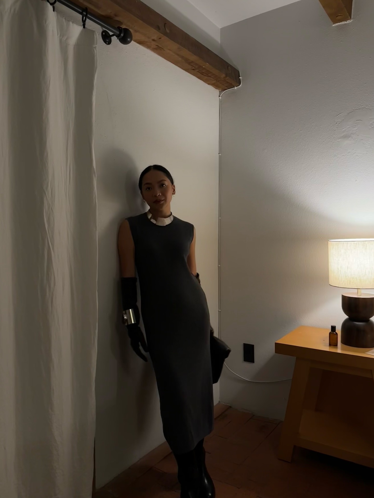 Dawn wears a gray sweater dress with black gloves and a silver necklace.