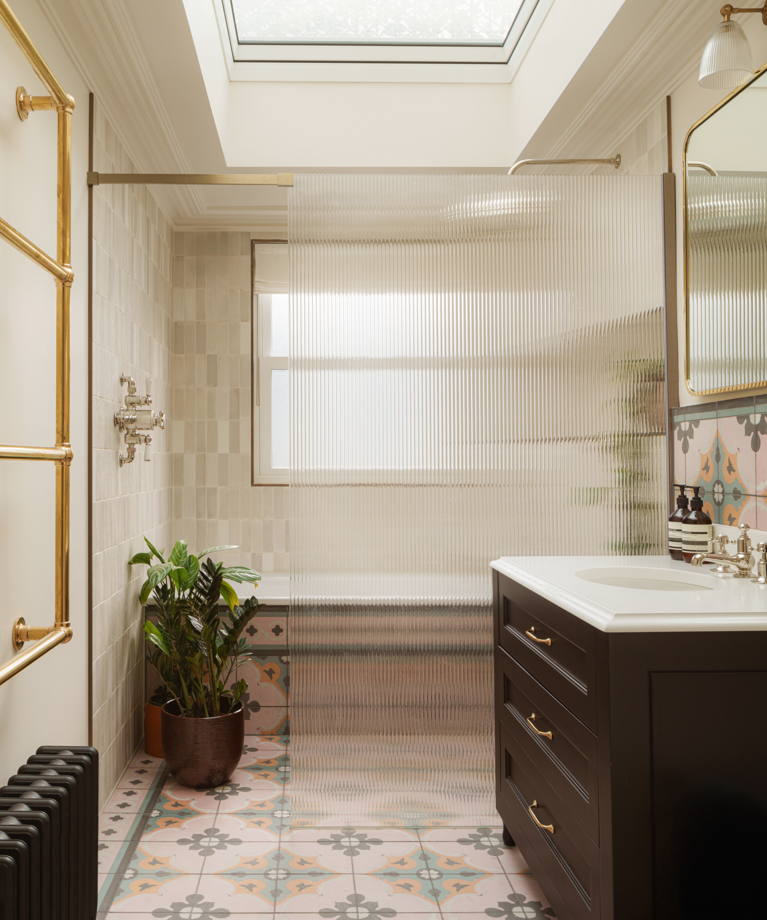 Bathroom with fluted shower screen, pink and green encaustic tiles and dark brown vanity