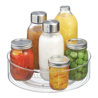 A clear Lazy Susan filled with kitchen condiments 